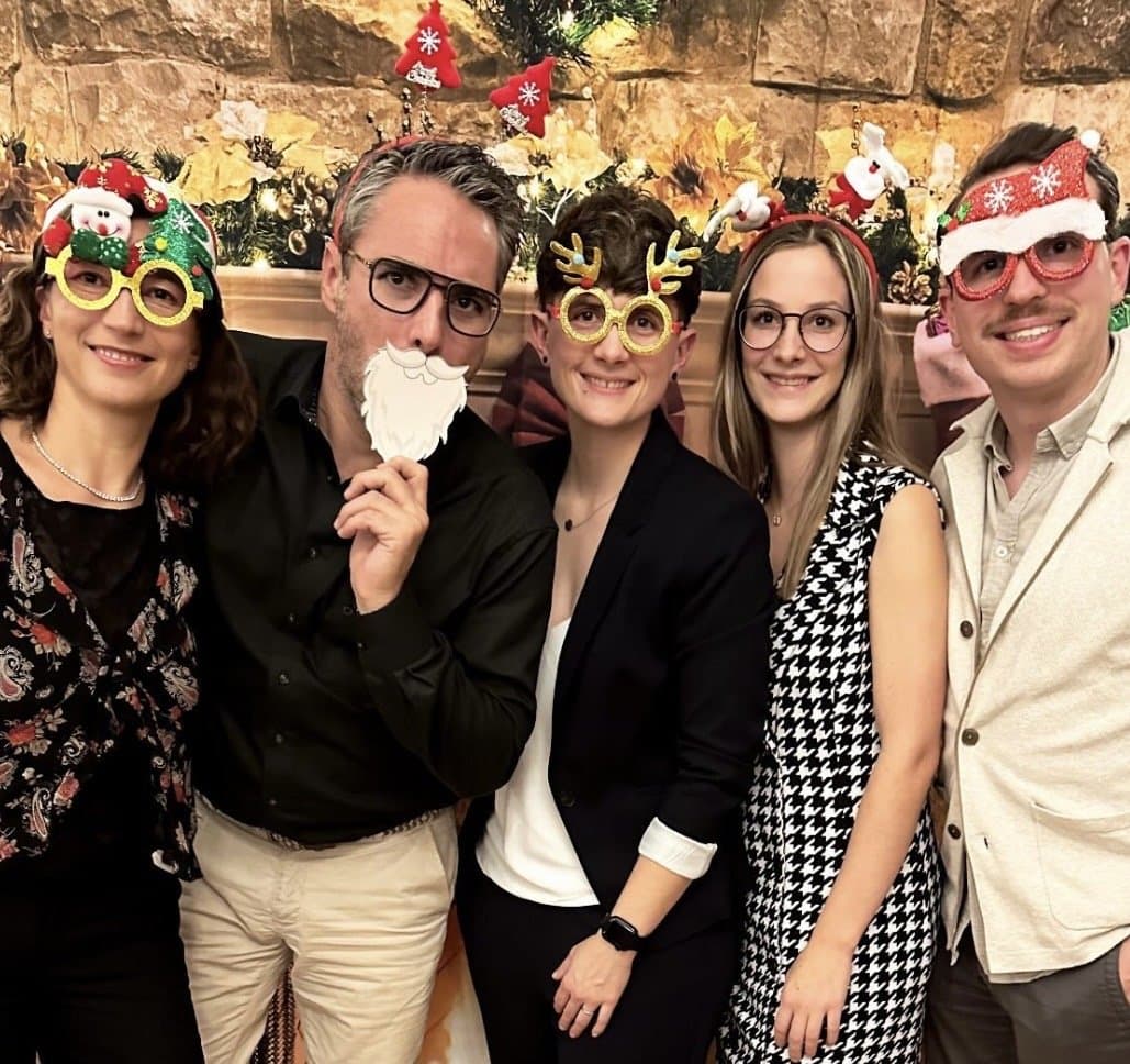Teammitglieder bei der Weihnachtsfeier mit festlichen Brillen und Haarreifen